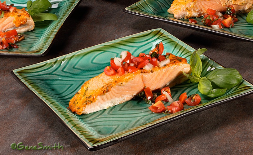 Heart Healthy baked salmon with tomatoe garnish on green plate