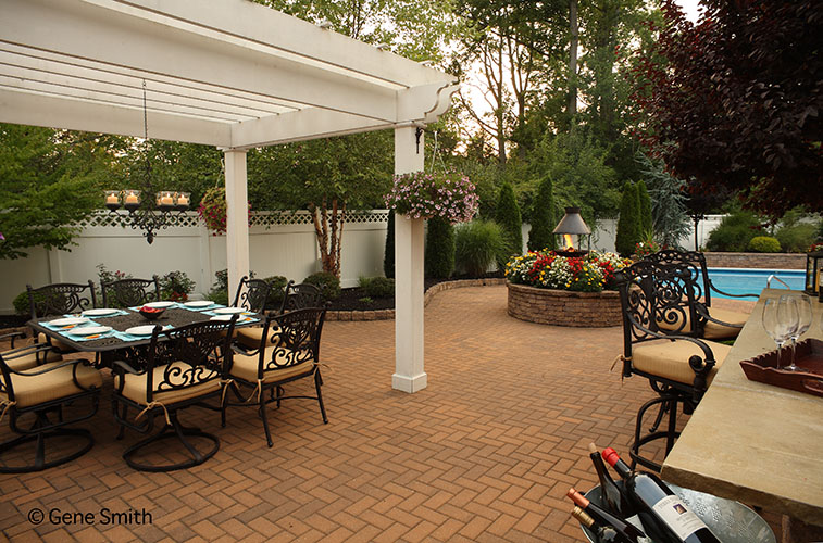 Brick patio and gazebo surround pool and outdoor bar and fire pit.