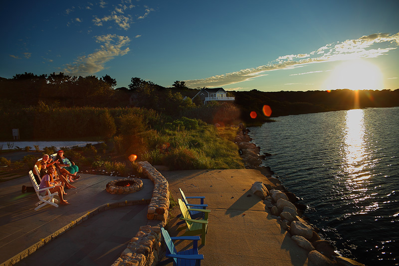 Extended family relaxes alongside SENGEKONTACKET POND in MArtha's Vineyard at sunset