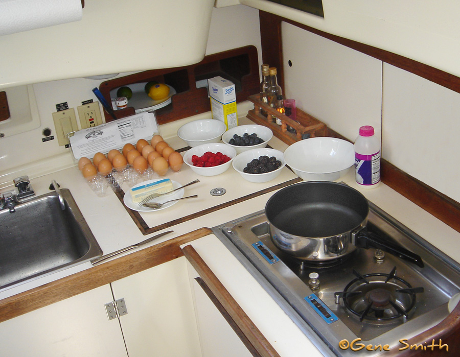 efficient little sailboat galley with eggs and berries ready to make hotcakes