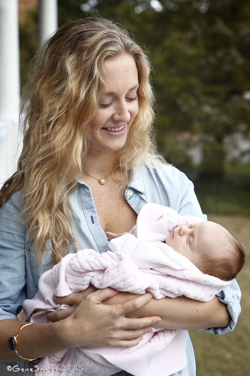 Pretty mother holds newborn girl outdoors in sylvan setting in Cape May, NJ