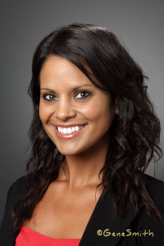 Young female professional corporate portrait headshot by Gene Smith on location with studio lighting and background.