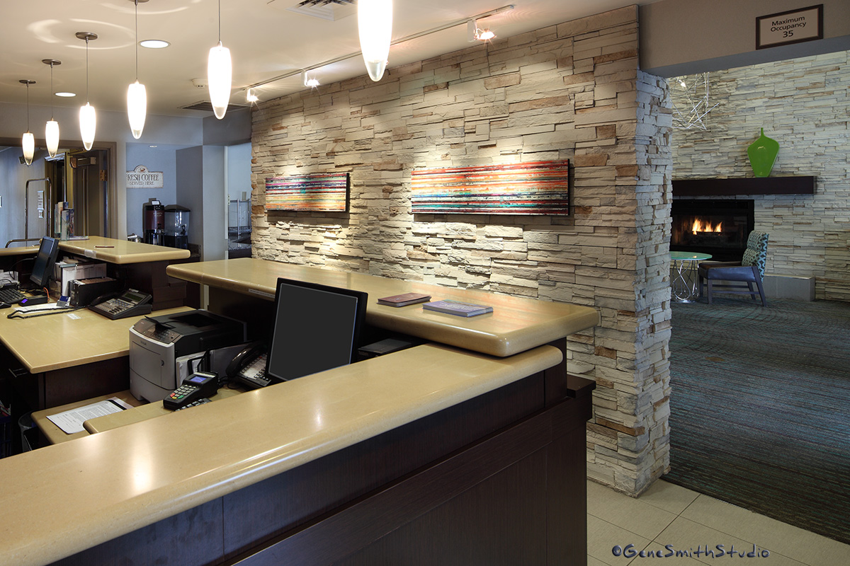 Hotel reception area and adjacent lounge with fireplace.